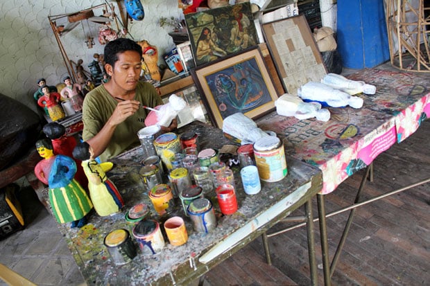 Artist hand painting his papier mâché creations in Balaw Balaw