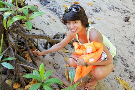 Happy tourist planting mangrove seedlings