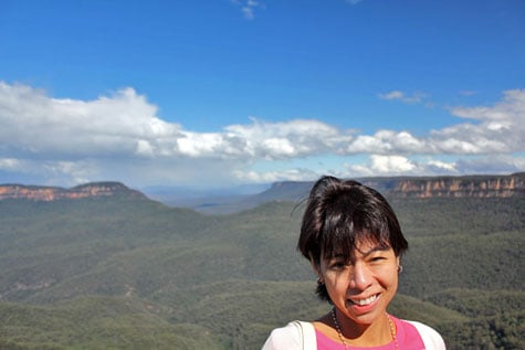 Tourist posing with Blue Mountains as backdrop, New South Wales, Australia