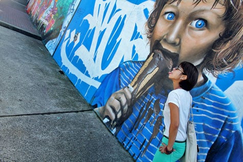 Tourist posing with mural at Bondi Beach, Sydney, Australia