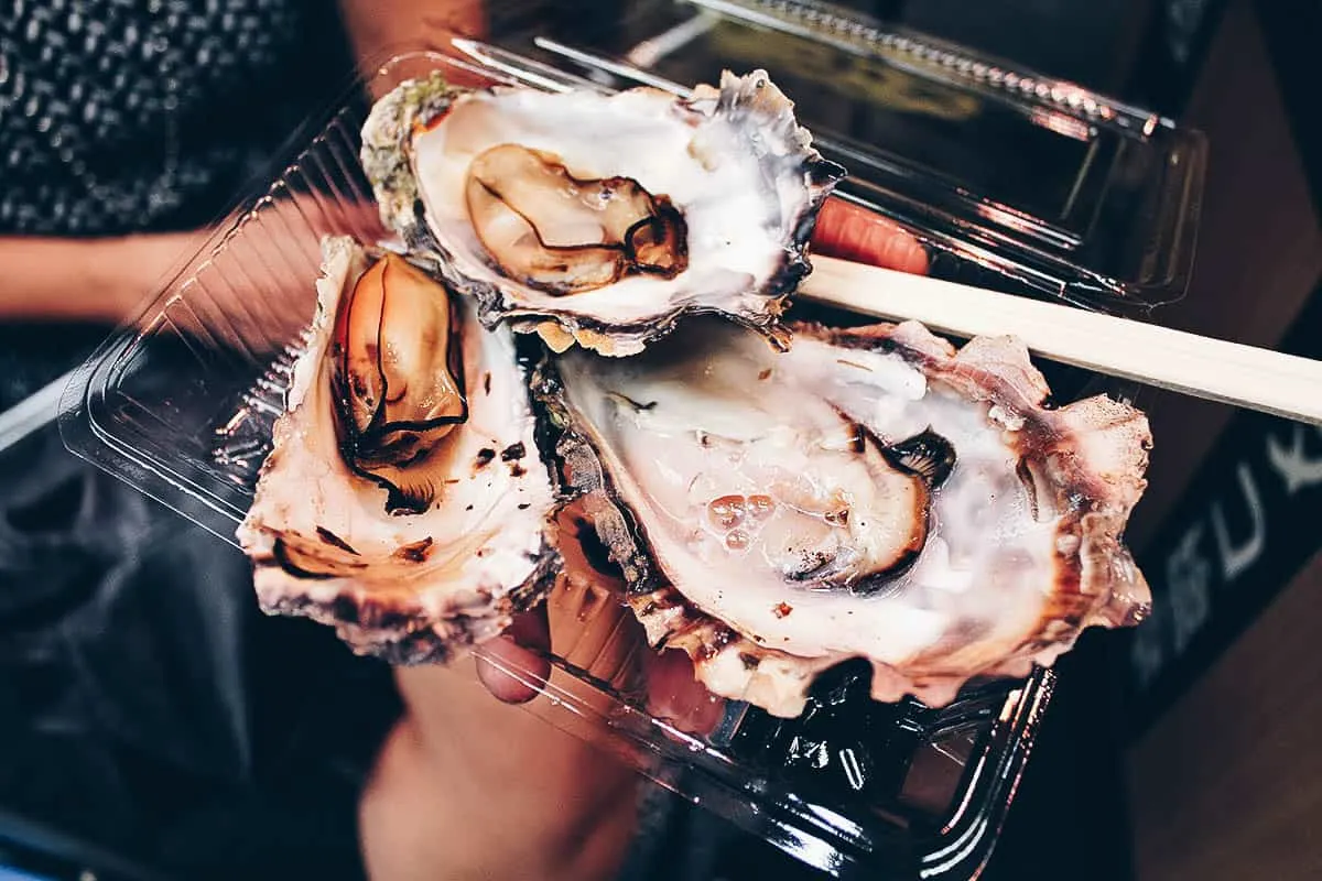 Grilling oysters at Kuromon Ichiba Market