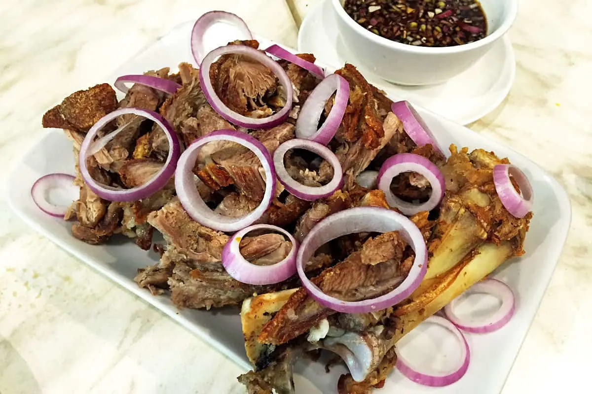 Filipino Food Guide Crispy pata with a dipping sauce made from soy sauce, garlic, and onions