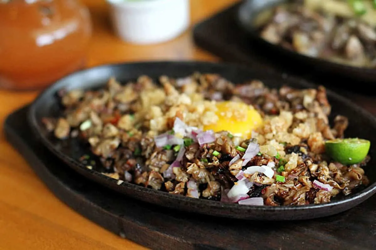 Filipino Food Guide Pork sisig with raw egg from Pampanga, a top food destination in the Philippines