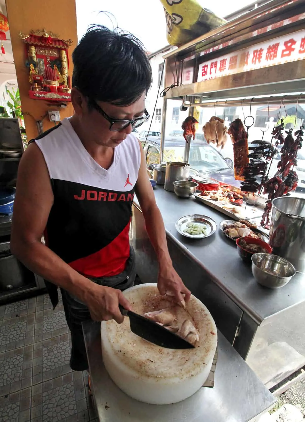 Chopping chicken at First Famous Federal Restaurant in Penang, Malaysia
