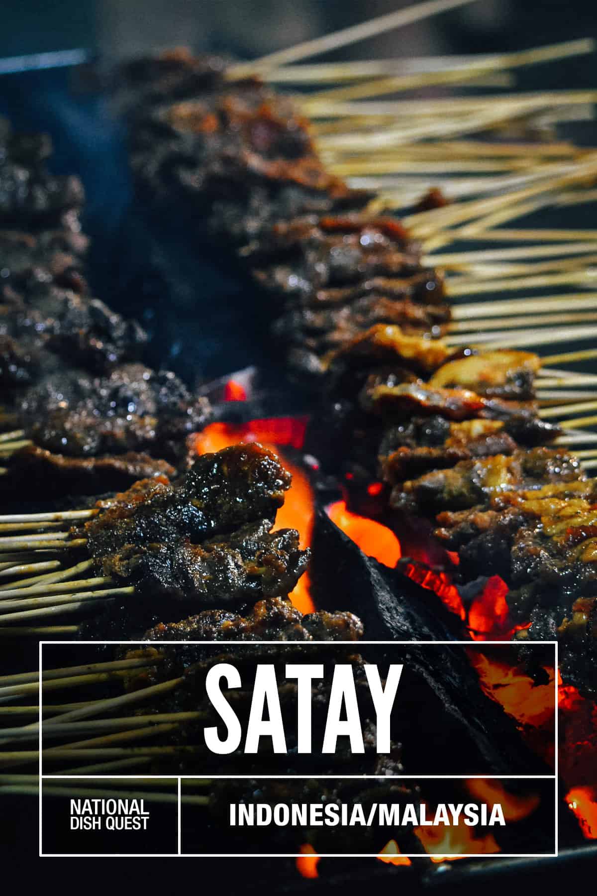 Sticks of satay grilling over coals
