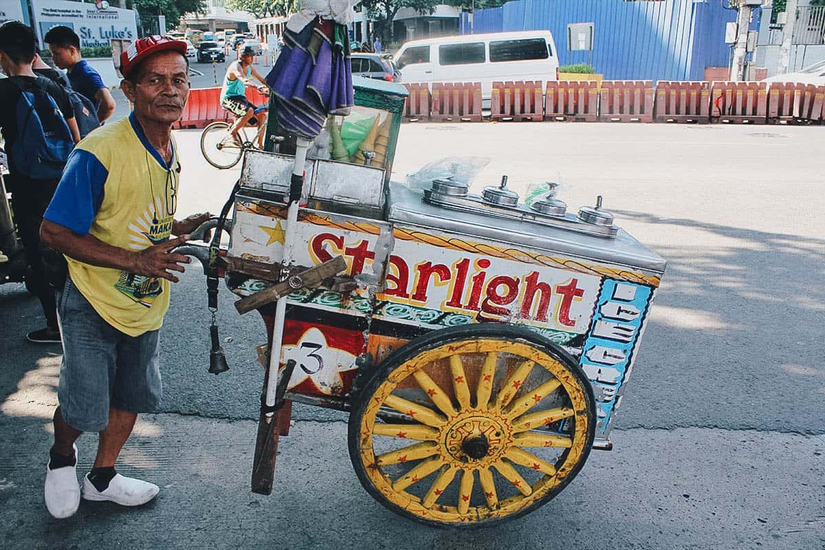 Filipino dirty ice cream vendor pushing his colorful cart