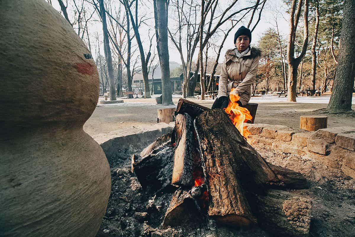 Ren sitting at a bonfire on Nami Island in South Korea