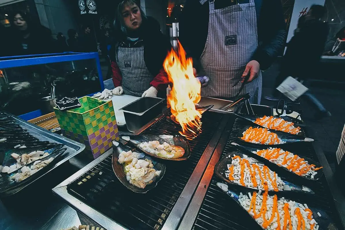 Things to Eat in South Korea Scallops with butter and cheese being cooked by street vendors