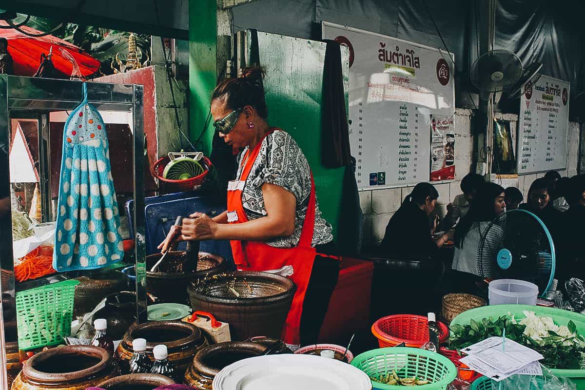 Woman preparing food at Som Tam Jay So restaurant in Bangkok