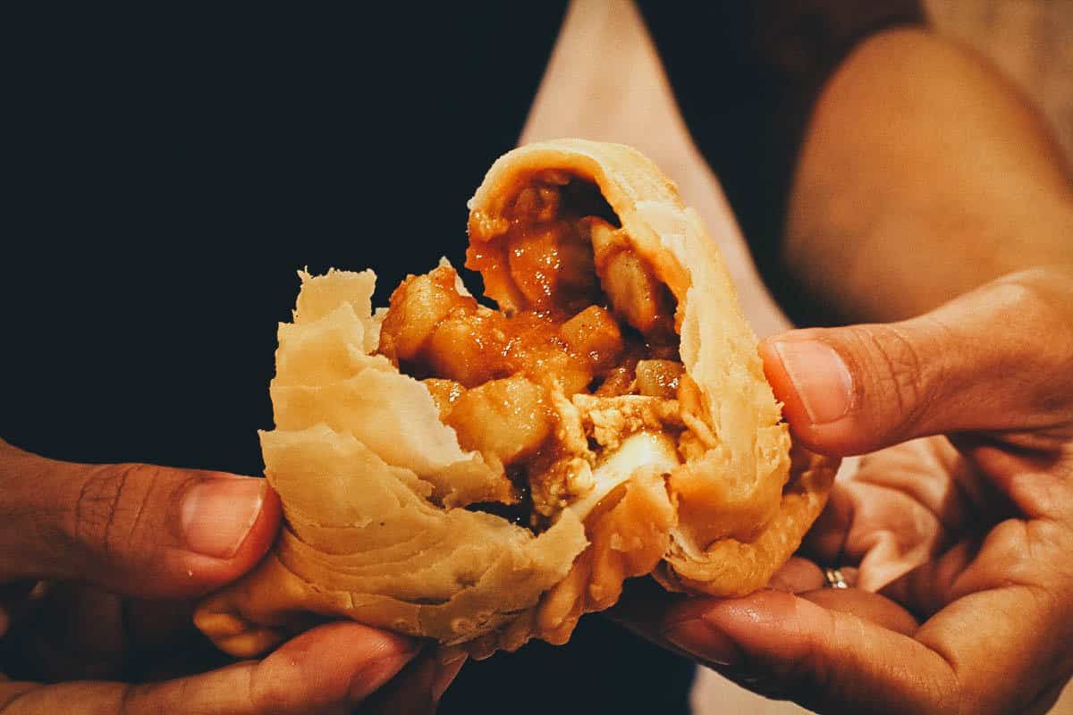 Breaking open a curry puff in Singapore