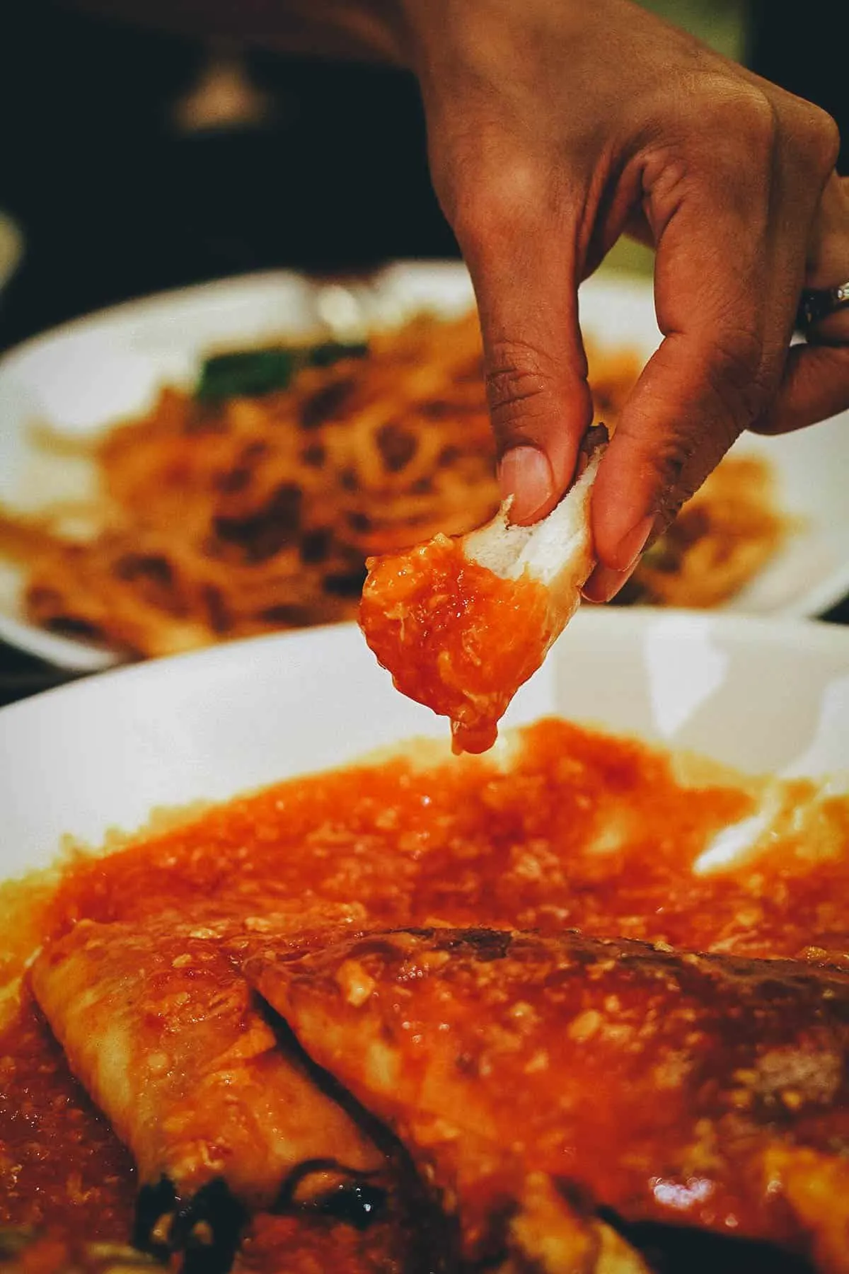 Dipping mantou bread in the crab chili sauce