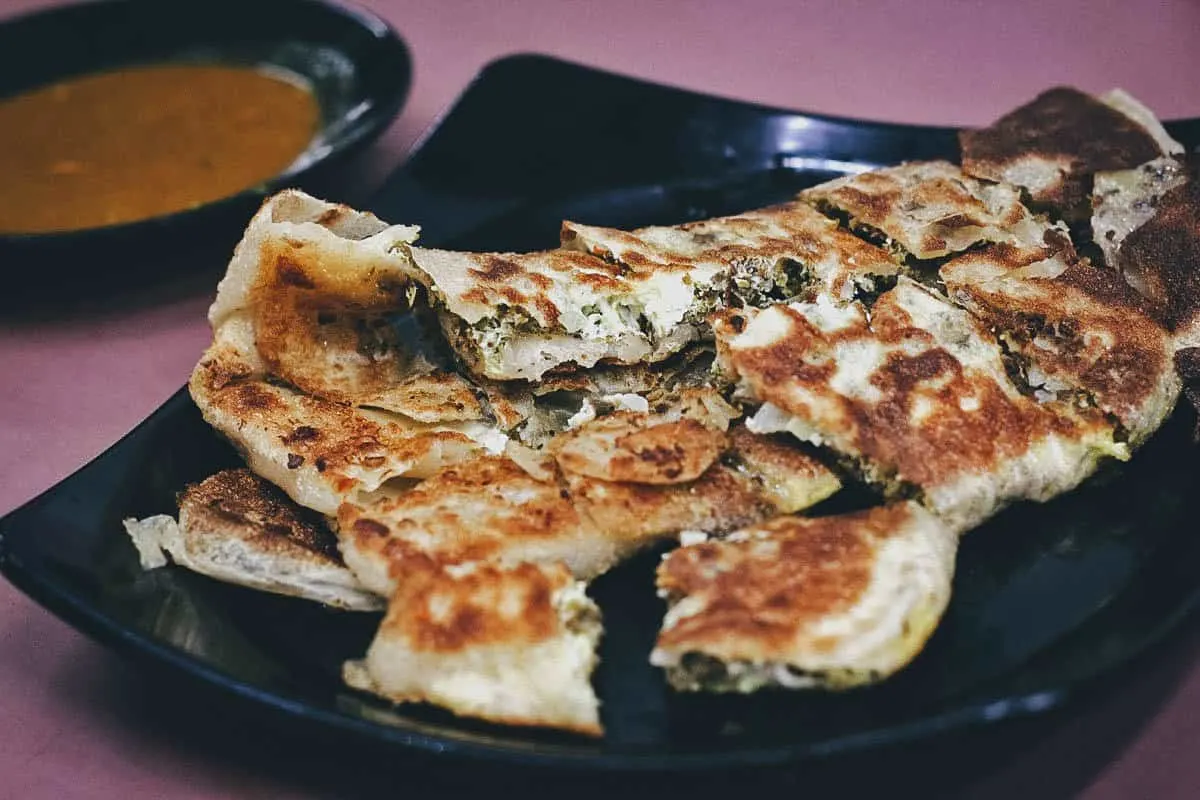 Plate of savory murtabak in Singapore, a stuffed version of roti prata