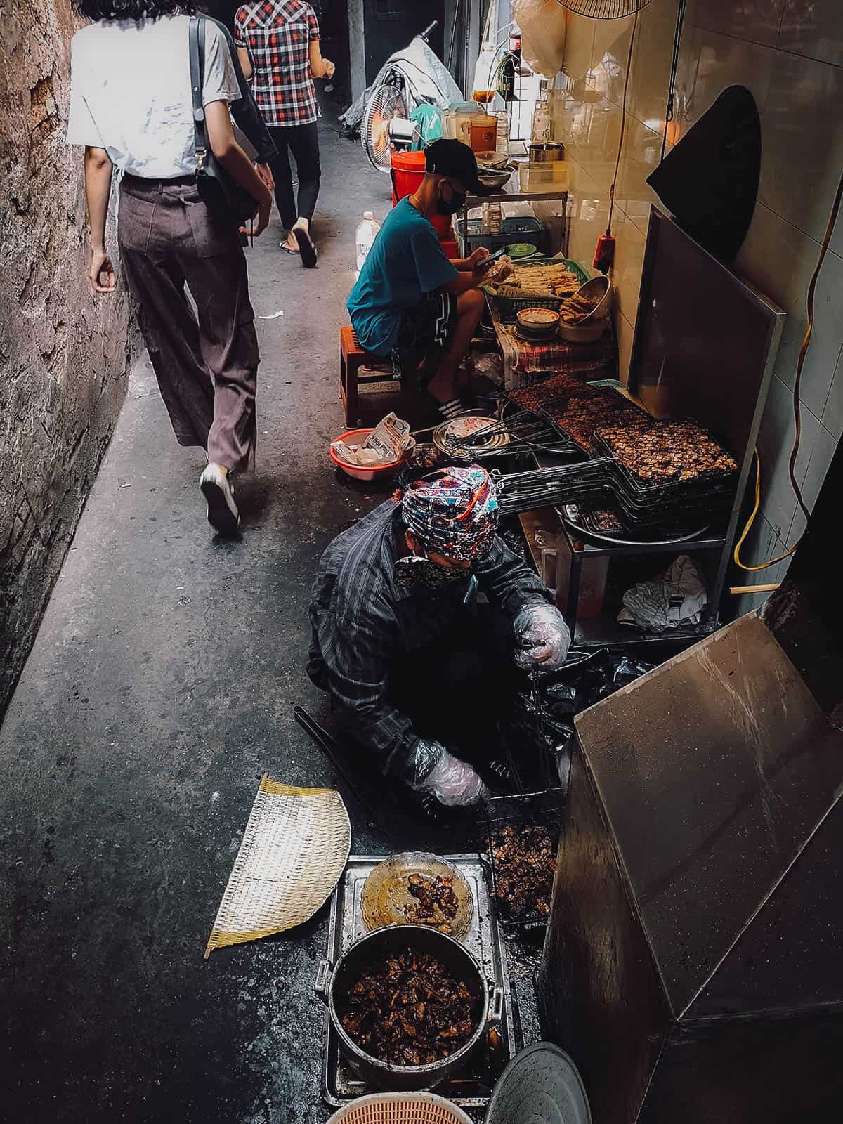 Grilling bun cha in an alley in Hanoi