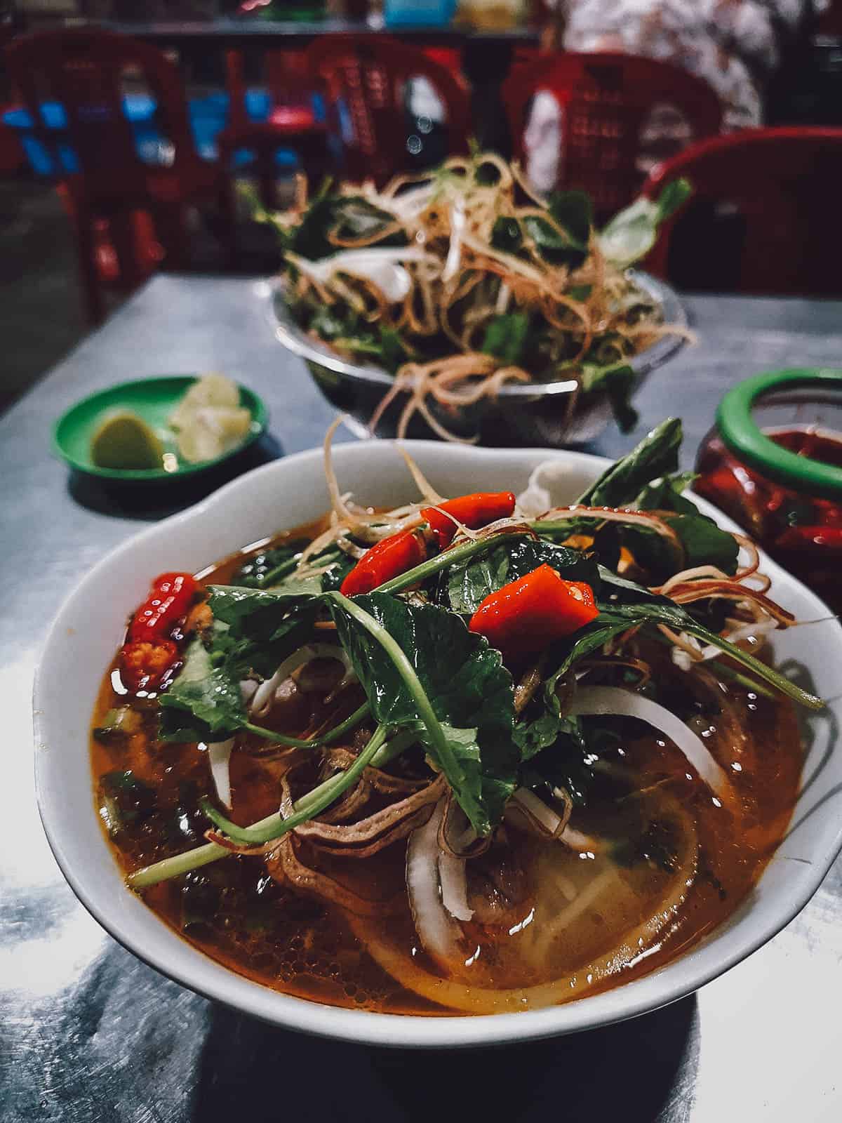 Bun bo topped with fresh greens at My Tam restaurant in Hue, Vietnam