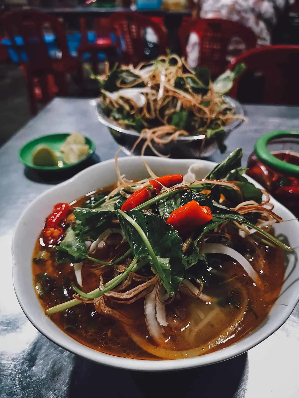 Bun bo topped with fresh greens at My Tam restaurant in Hue, Vietnam