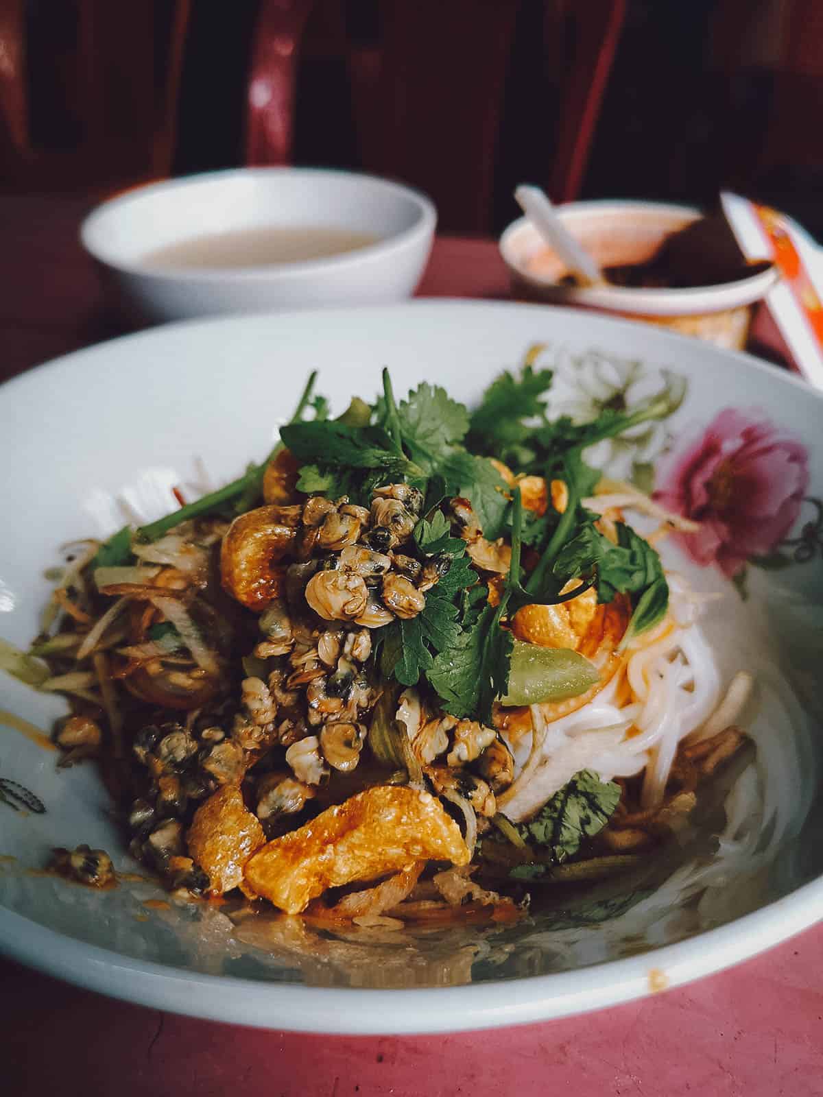 Bun hen topped with peanuts and banana flower salad at a restaurant in Hue