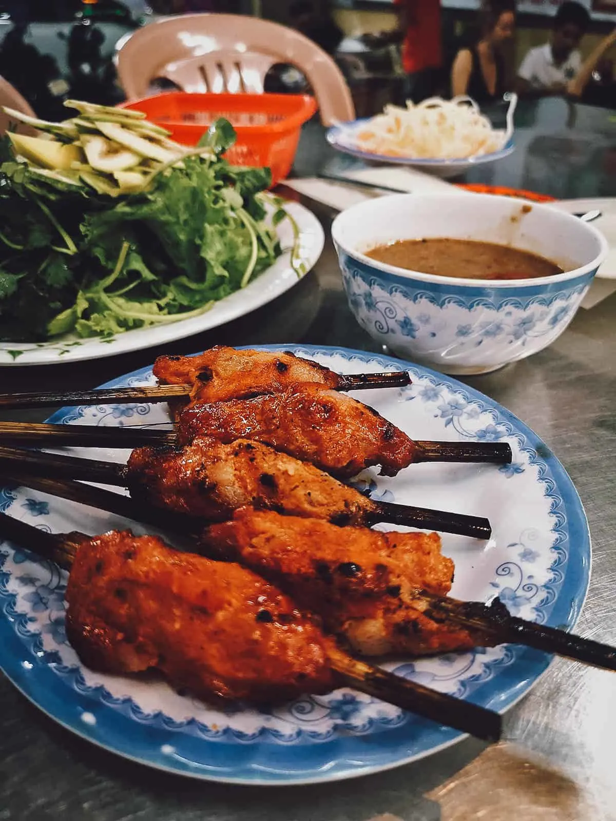 Nem lui, a tasty Vietnamese dish made with skewered grilled fatty pork and peanut sauce