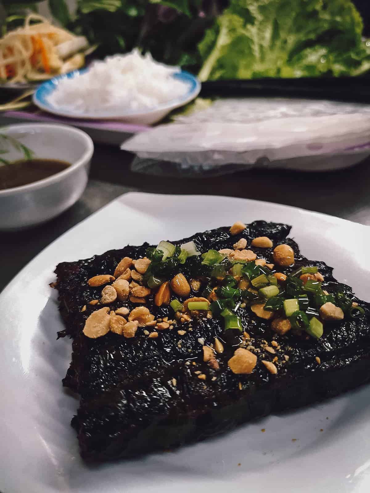 Bo la lot in Saigon, a popular Vietnamese food made with ground beef wrapped in betel leaf