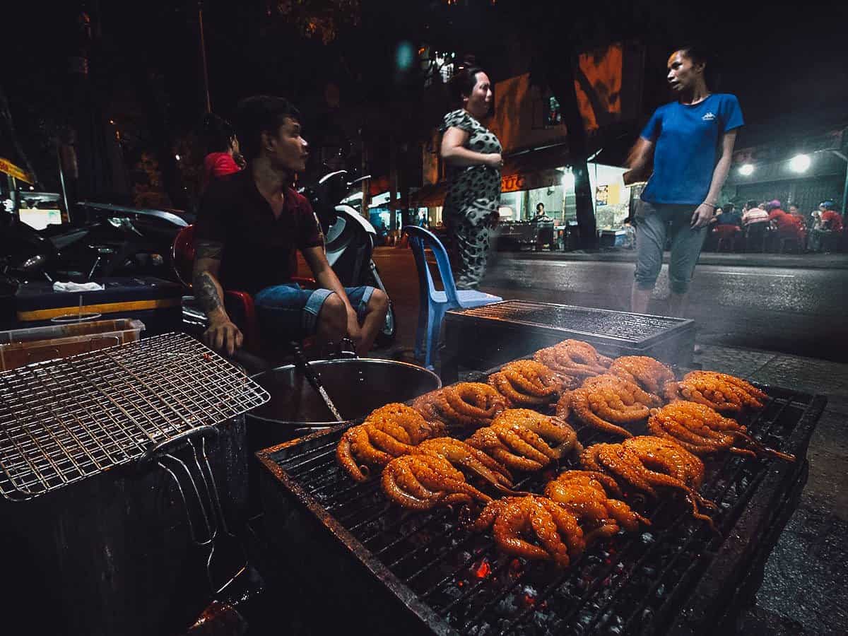 Grilling octopus along Vinh Khanh Street in Saigon
