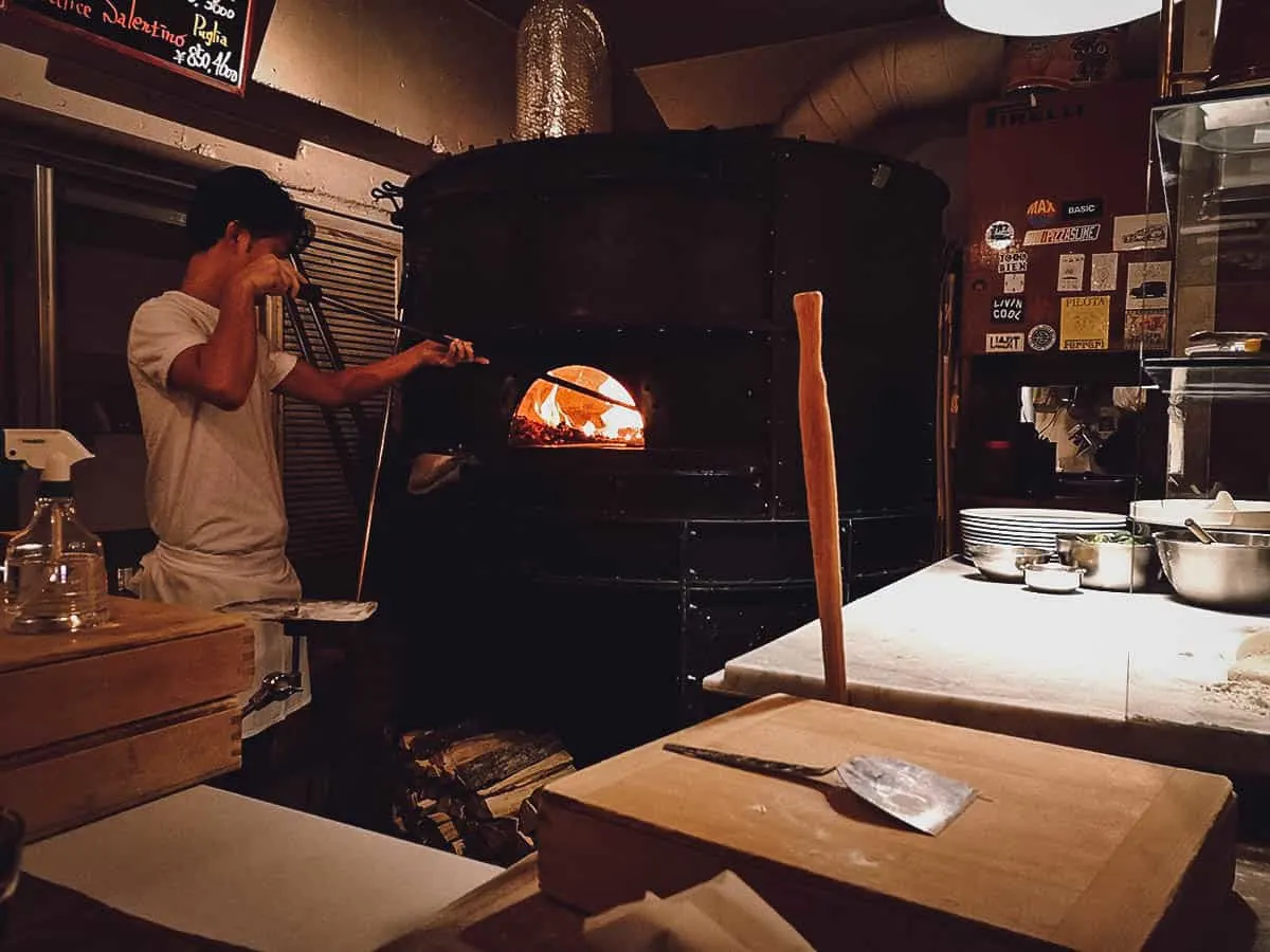 Putting pizza in the brick oven at Savoy in Tokyo, Japan