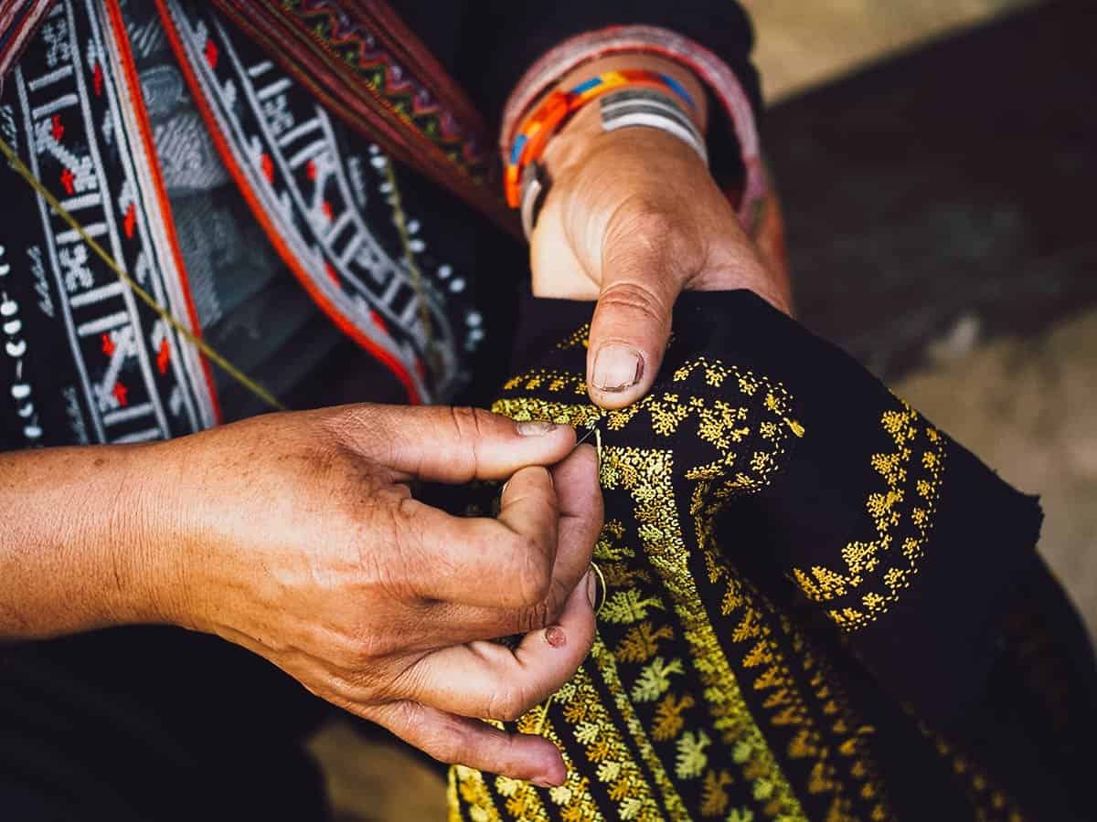 Sewing in Sapa, Vietnam Woman sewing on black fabric