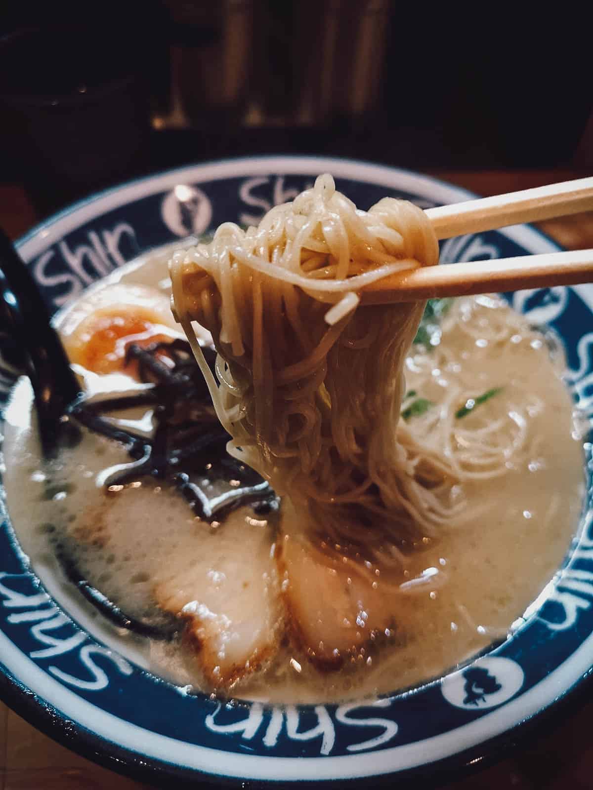 Bowl of Hakata or tonkotsu ramen with wheat noodles, ramen egg, and thin slices of chashu pork