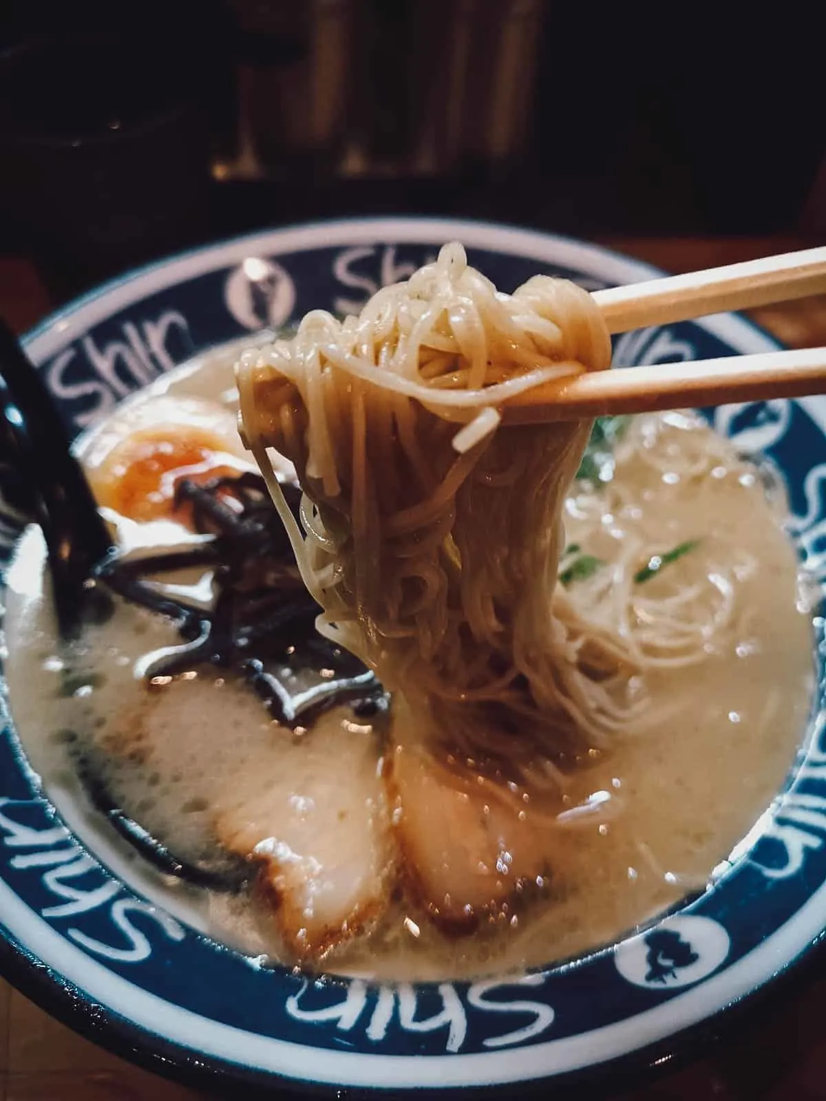 Japanese Food Guide Bowl of Hakata or tonkotsu ramen with wheat noodles, ramen egg, and thin slices of chashu pork