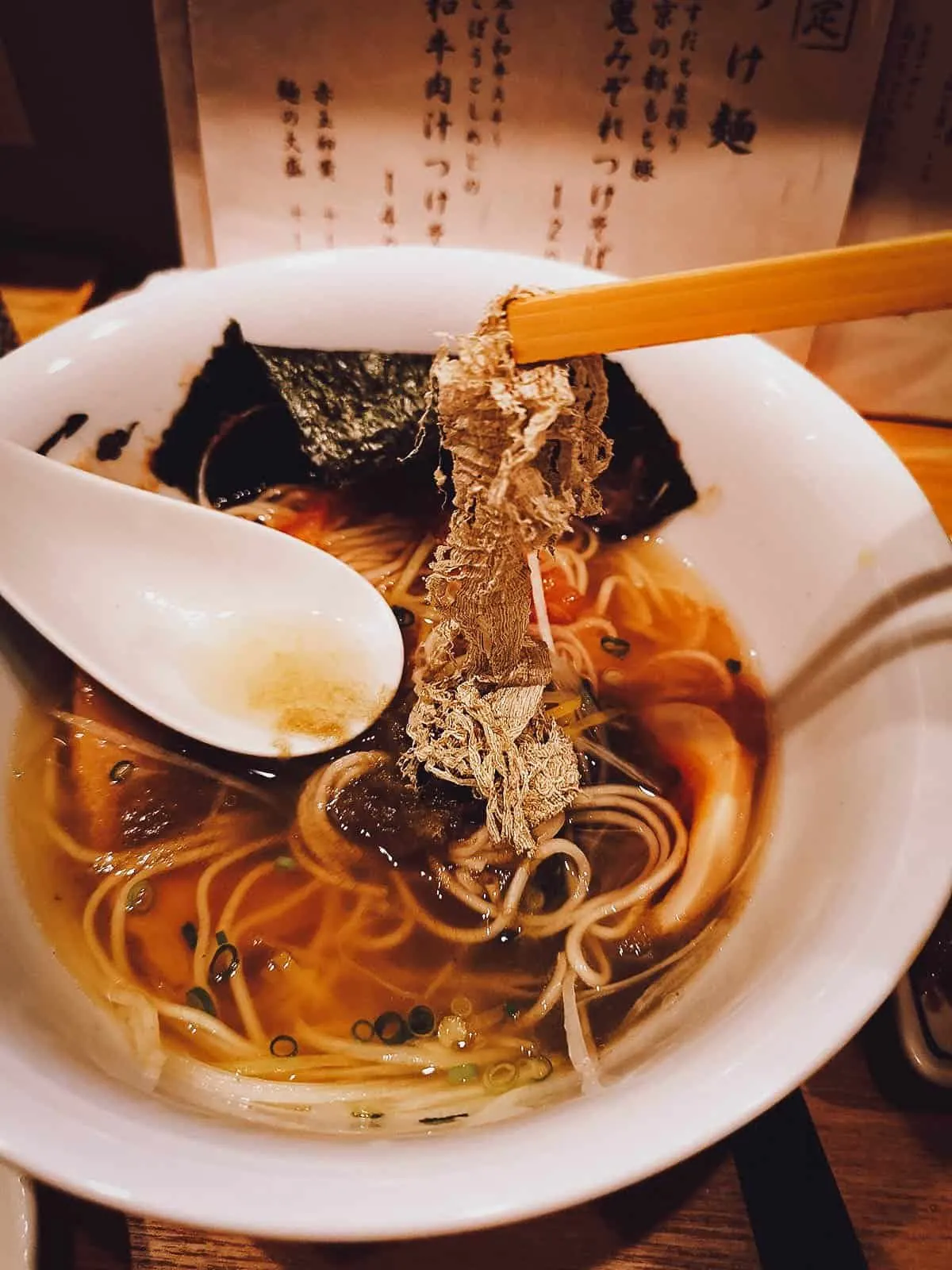 Adding condiments to ramen at a restaurant in Kyoto