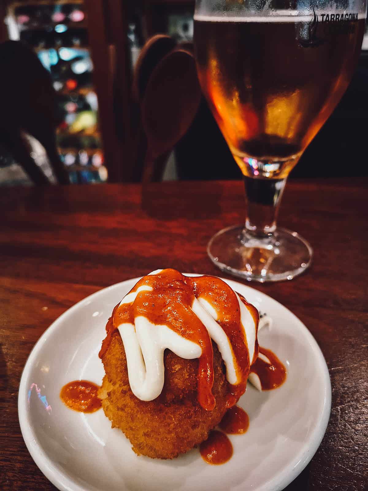 Bomba and beer at a restaurant in Barcelona