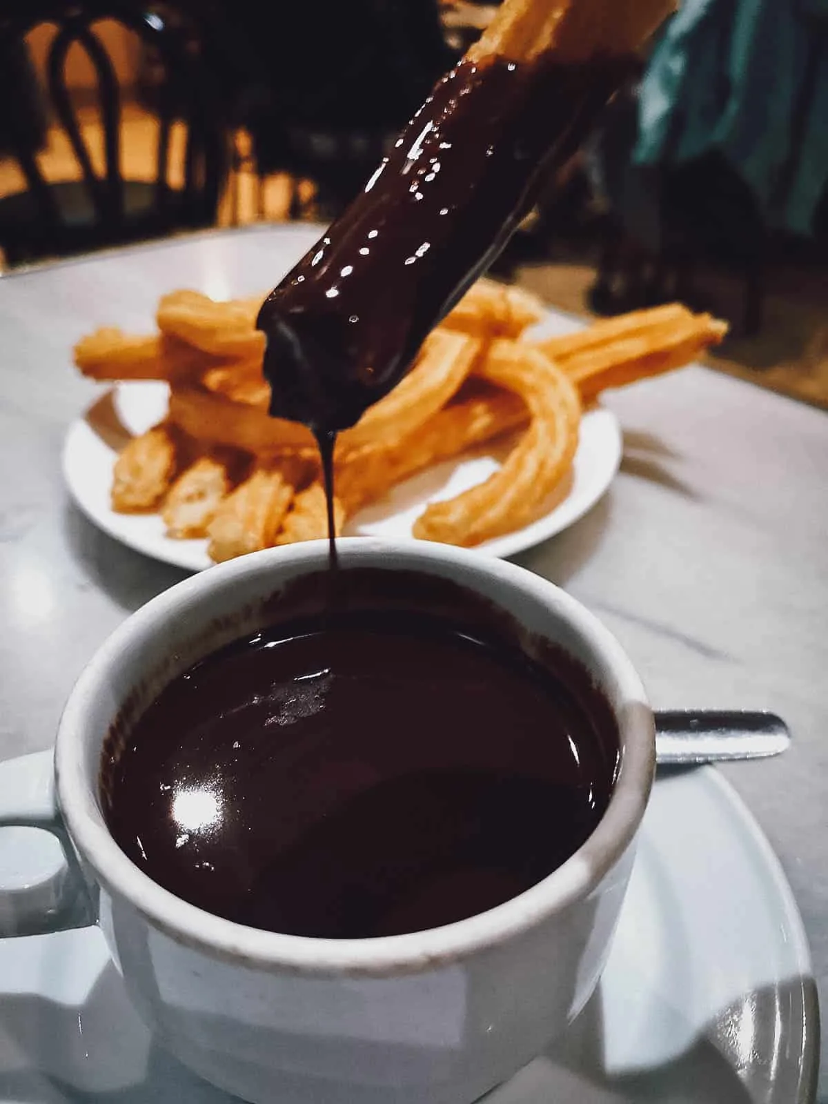 Madrid Food Guide: 14 Must-Try Restaurants, Bars, and Markets Churros dipped in chocolate