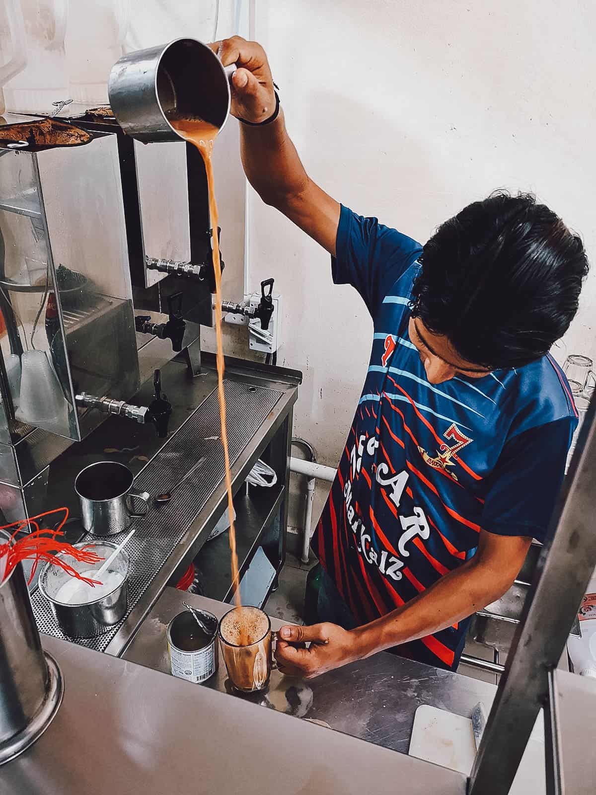 Pouring teh tarik in a glass in Singapore