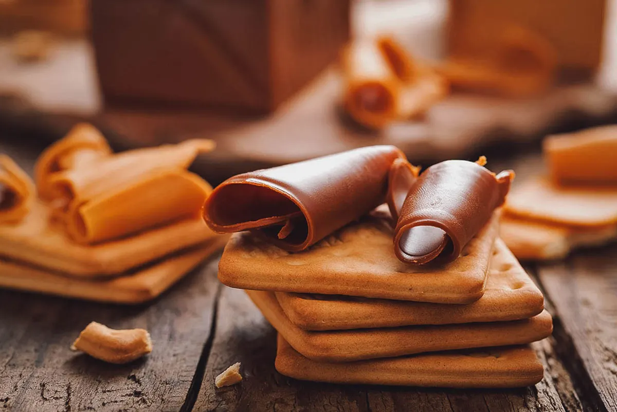 Slivers of brunost or Norwegian brown cheese cut with a cheese slicer