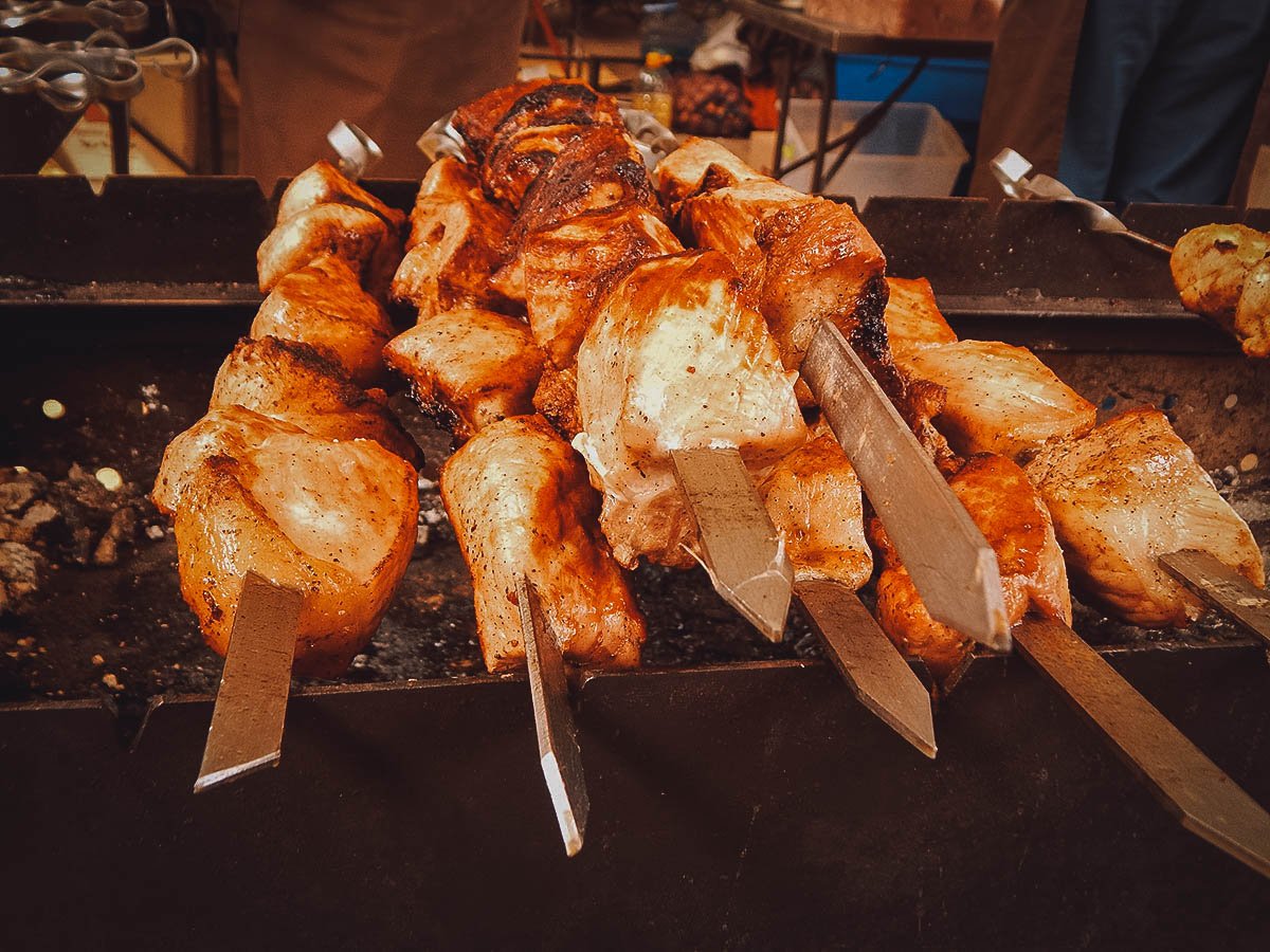 Grilling marinated shashlik preparing on a barbecue grill over charcoal.  Shashlik is a form of Shish kebab popular in Eastern Europe. Shashlyk (meaning  skewered meat) was originally made of lamb. Stock Photo