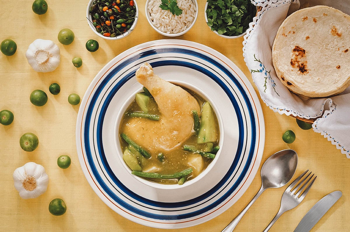 Jocon de polo or Guatemalan chicken stew with bread, sides, and ingredients