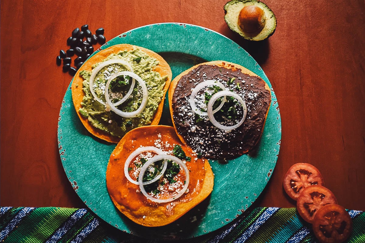 Tostadas with black beans, tomto sauce, and guacamole – a popular street food snack in Guatemala