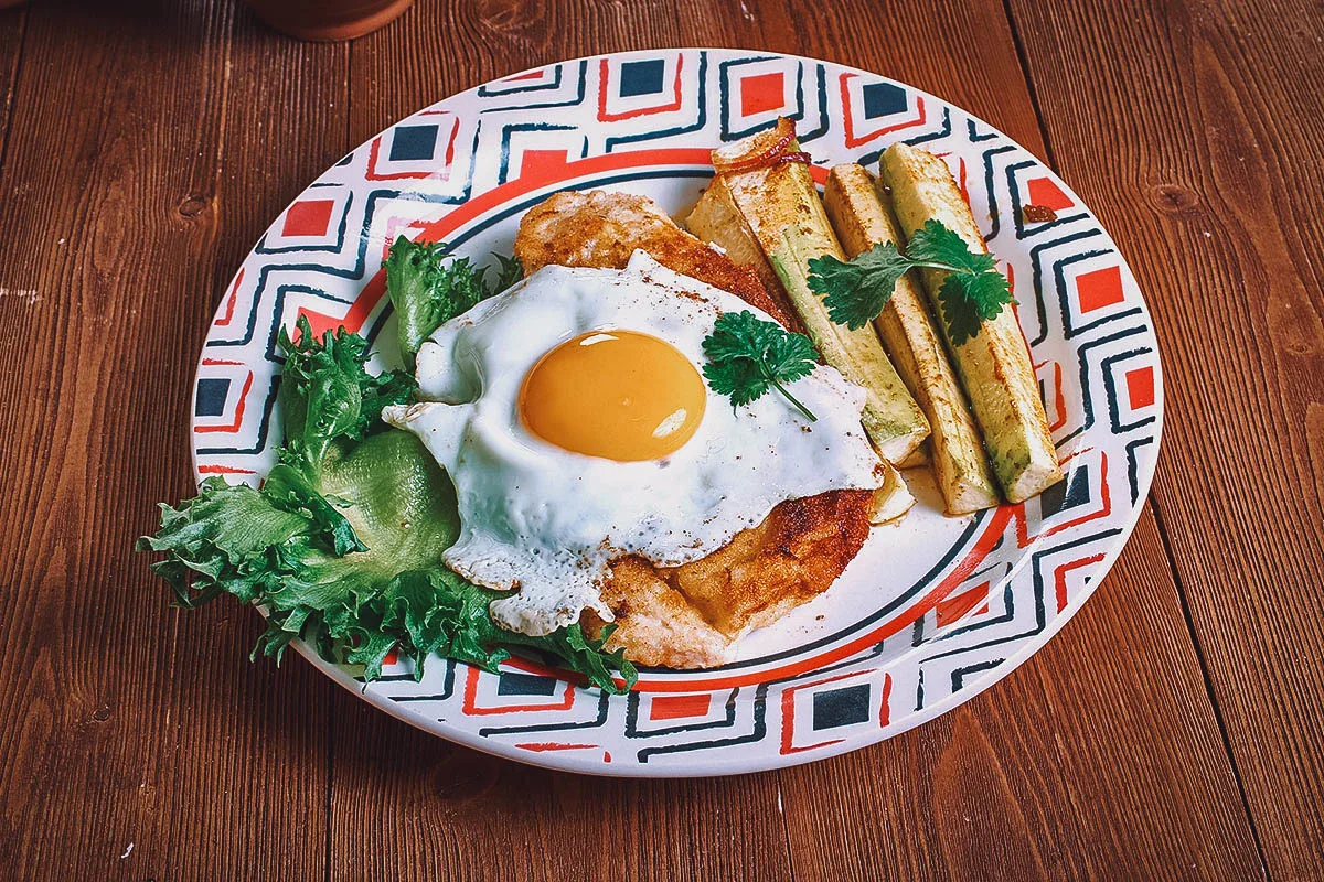 Argentinian Food Milanesa with fried eggs and french fries
