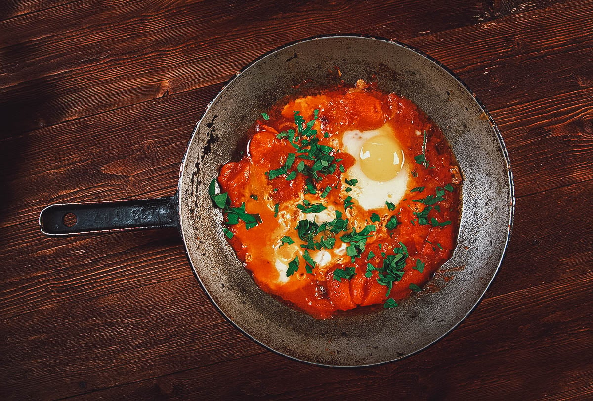 Top view of shakshouka, a popular North African dish made with poached eggs, bell peppers, and tomato sauce