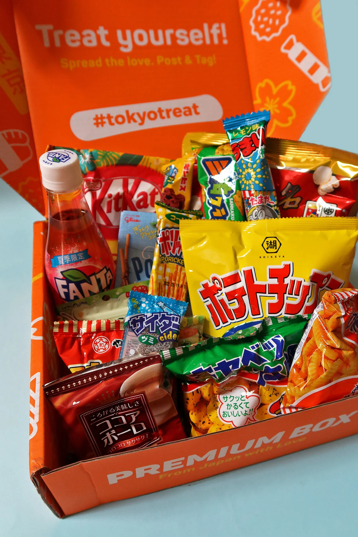 TokyoTreat's signature orange box loaded with Kit Kat bars, snack chips, party pack candies, drinks, DIY kits, etc