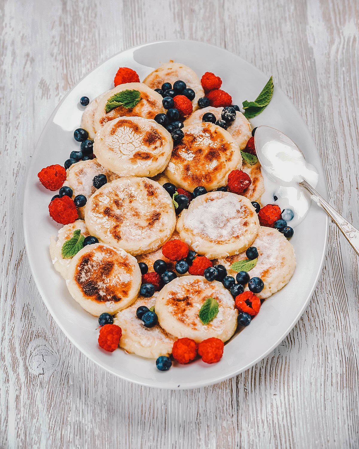 Platter of syrniki and berries