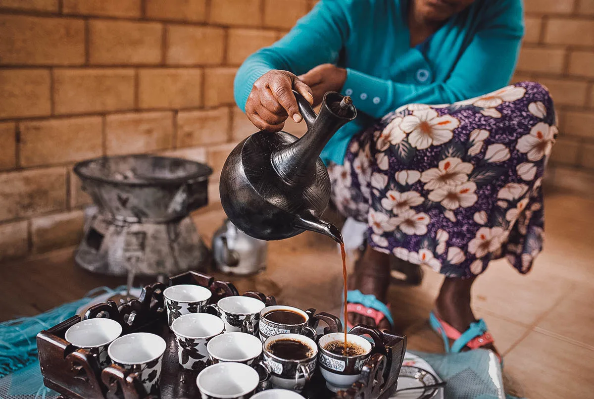 Ethiopian Food Woman pouring Ethiopian coffee in a dedicated coffee area