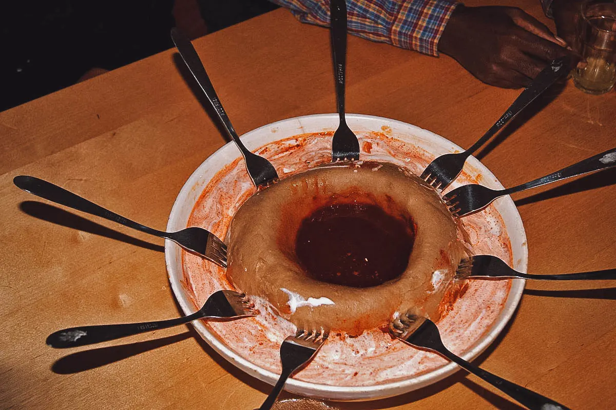 Ethiopian Food Genfo with berbere sauce in the middle and forks all around