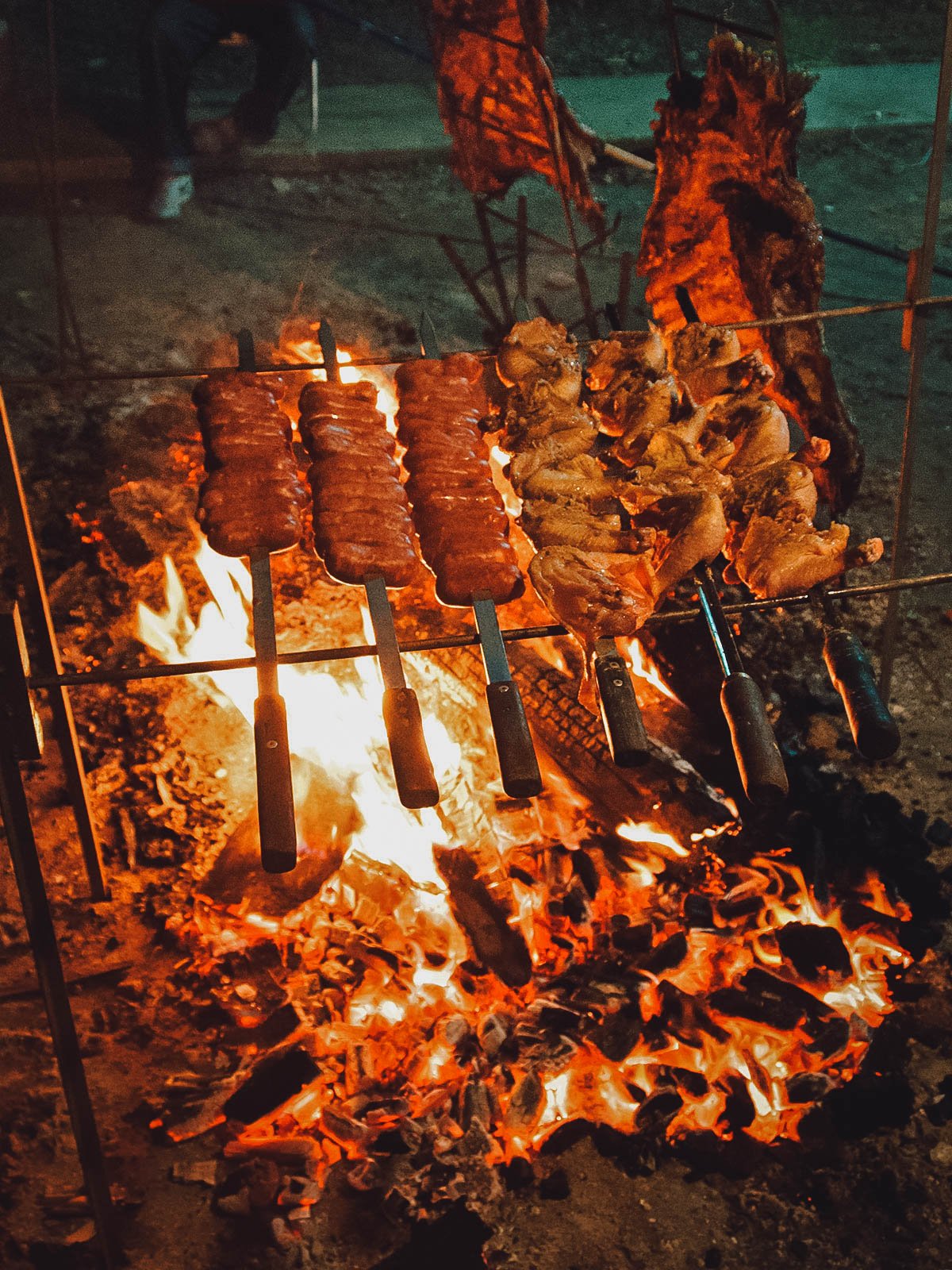 Churrasco meats grilling over a fire, one of the most delicious Brazilian traditions