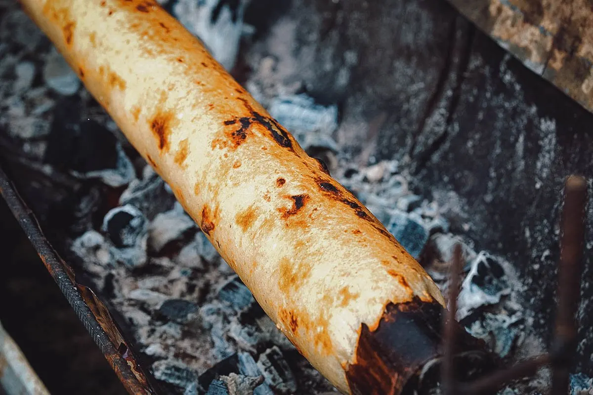 Chilean Food Chochoca roasting on a metal cylinder