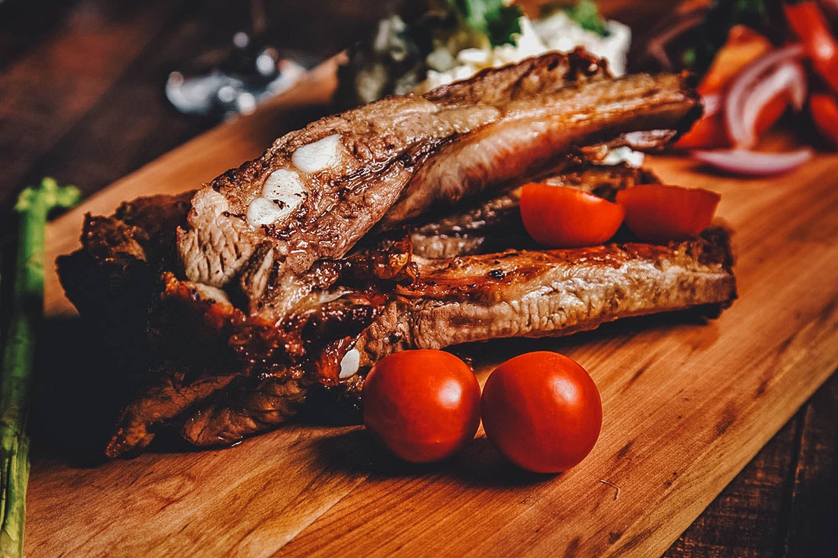Costillar de chancho on a chopping board with tomatoes
