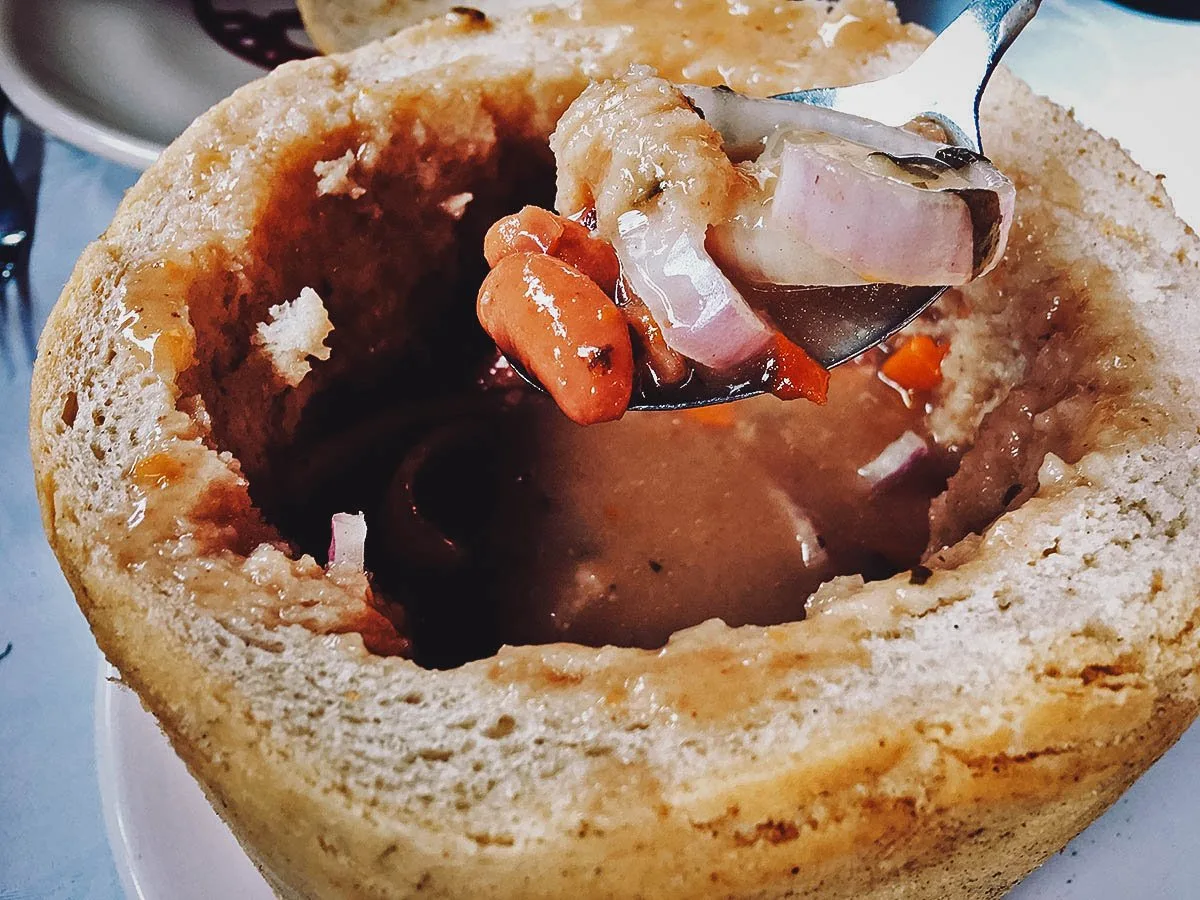 Romanian Food Ciorba de fasole, a sour Romanian soup made with beans, carrots, raw onions, and tomatoes