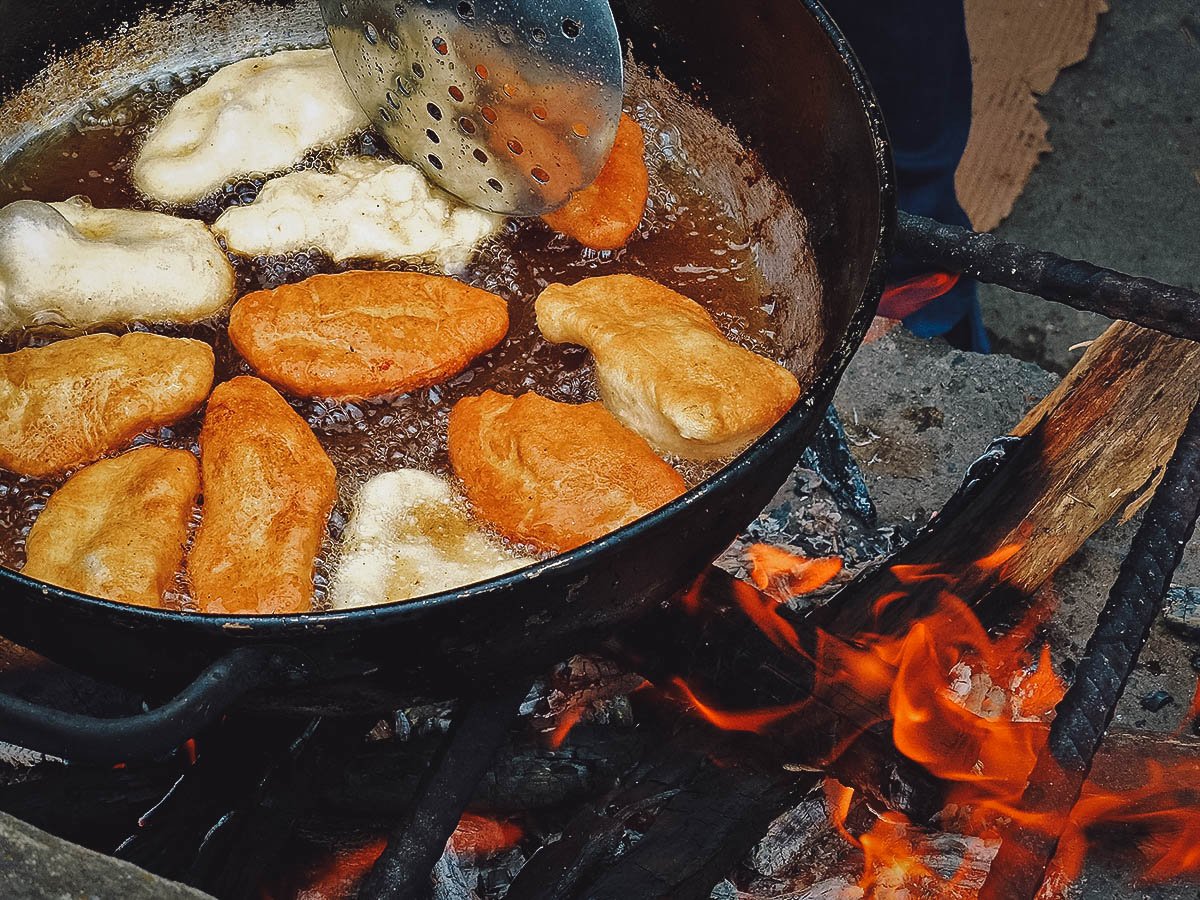 Ecuadorian empanadas deep-frying in a pot