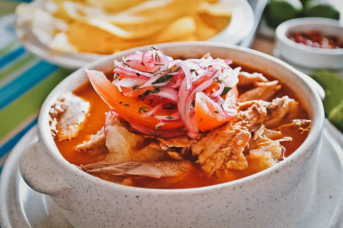 Bowl of encebollado, an Ecuadorian soup made with fish, yuca, and red onion salsa