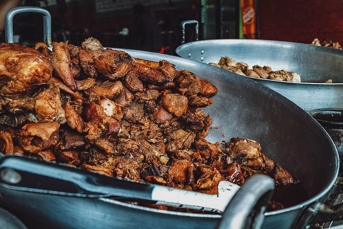 Large batch of fritada de chancho, a traditional food in Ecuador made with braised pork