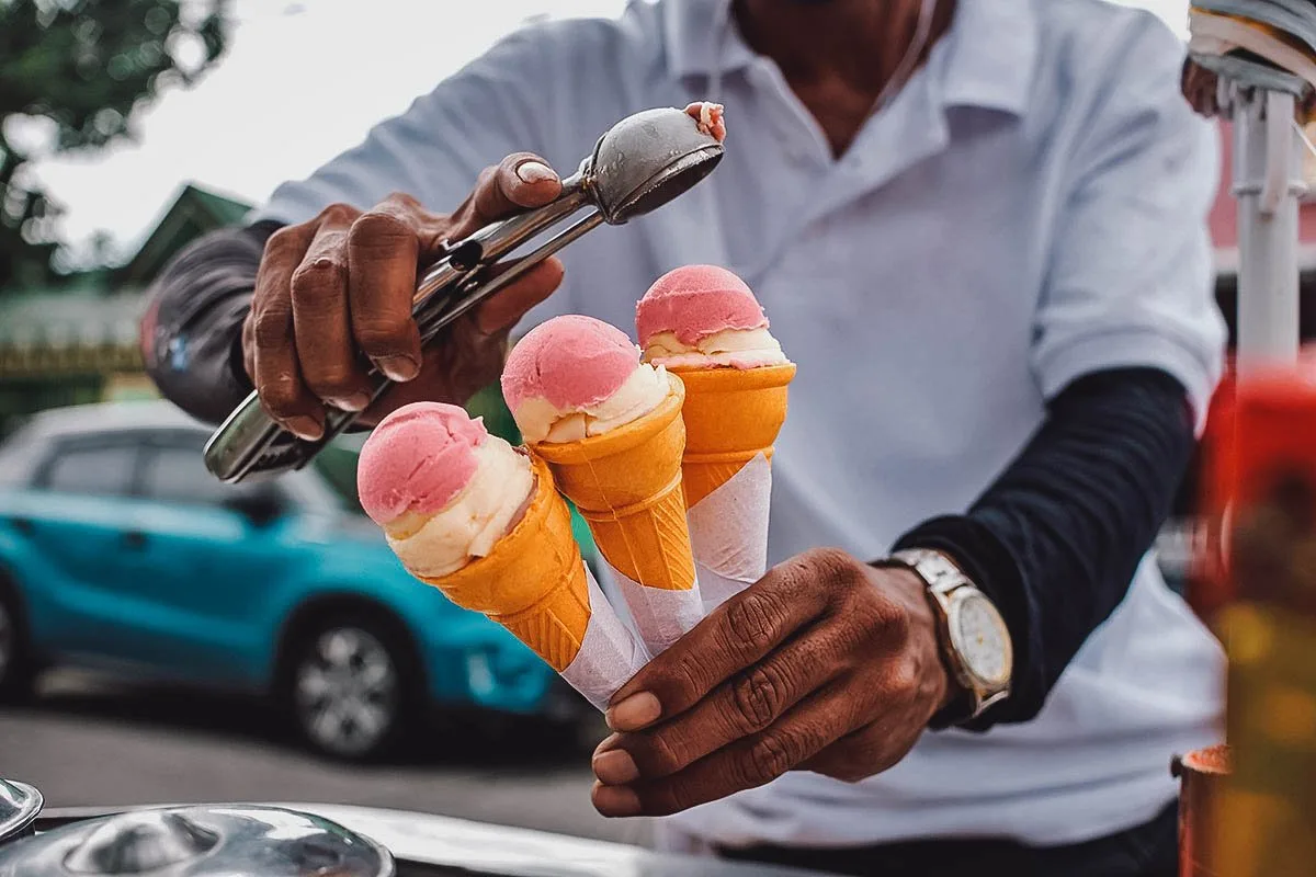 Filipino Desserts Ice cream vendor scooping sorbetes or Filipino dirty ice cream