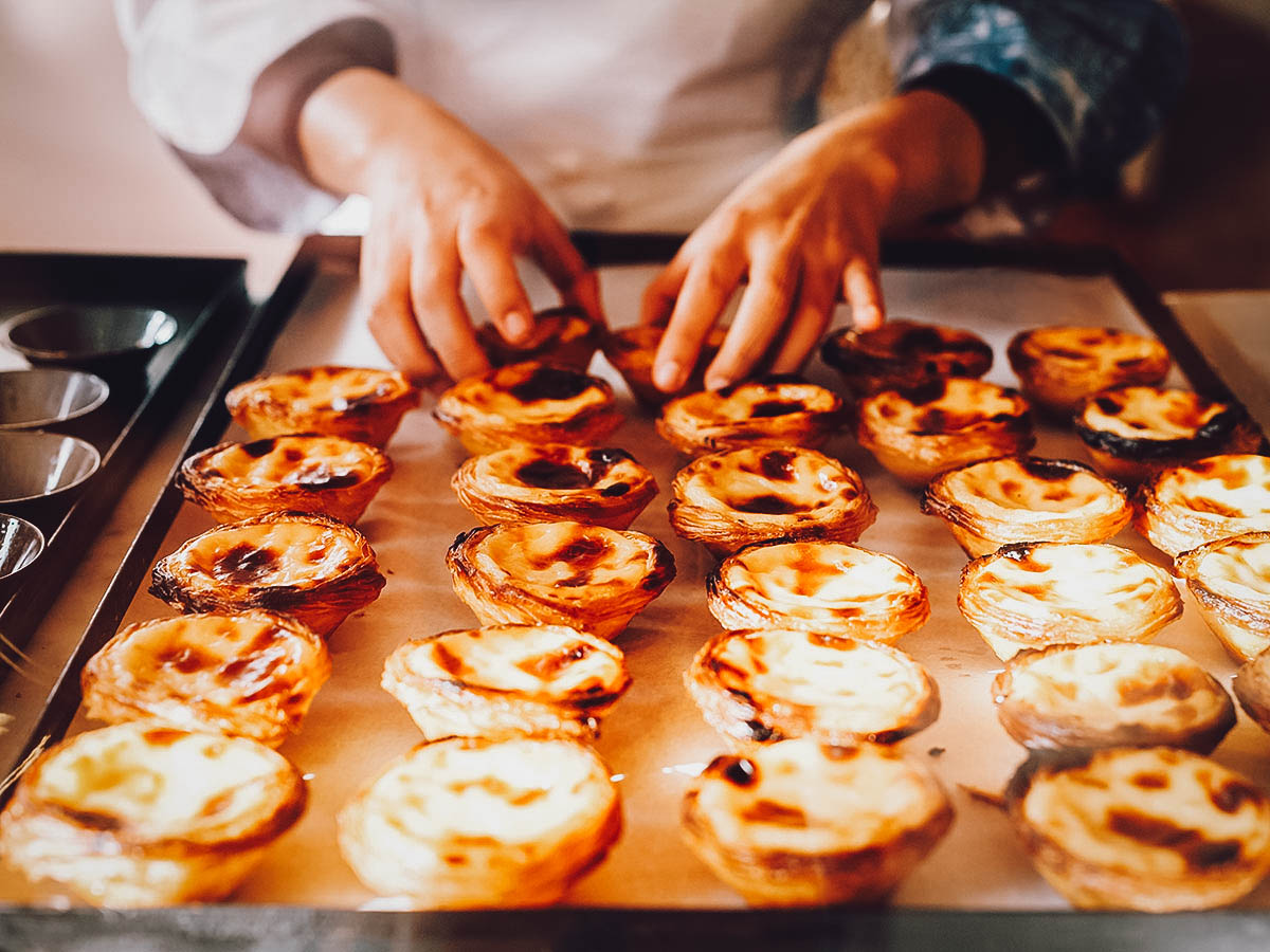 Woman baking pastel de nata in Lisbon, Portugal